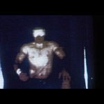 TV screen capture of shirtless, muscular man, face indistinct
